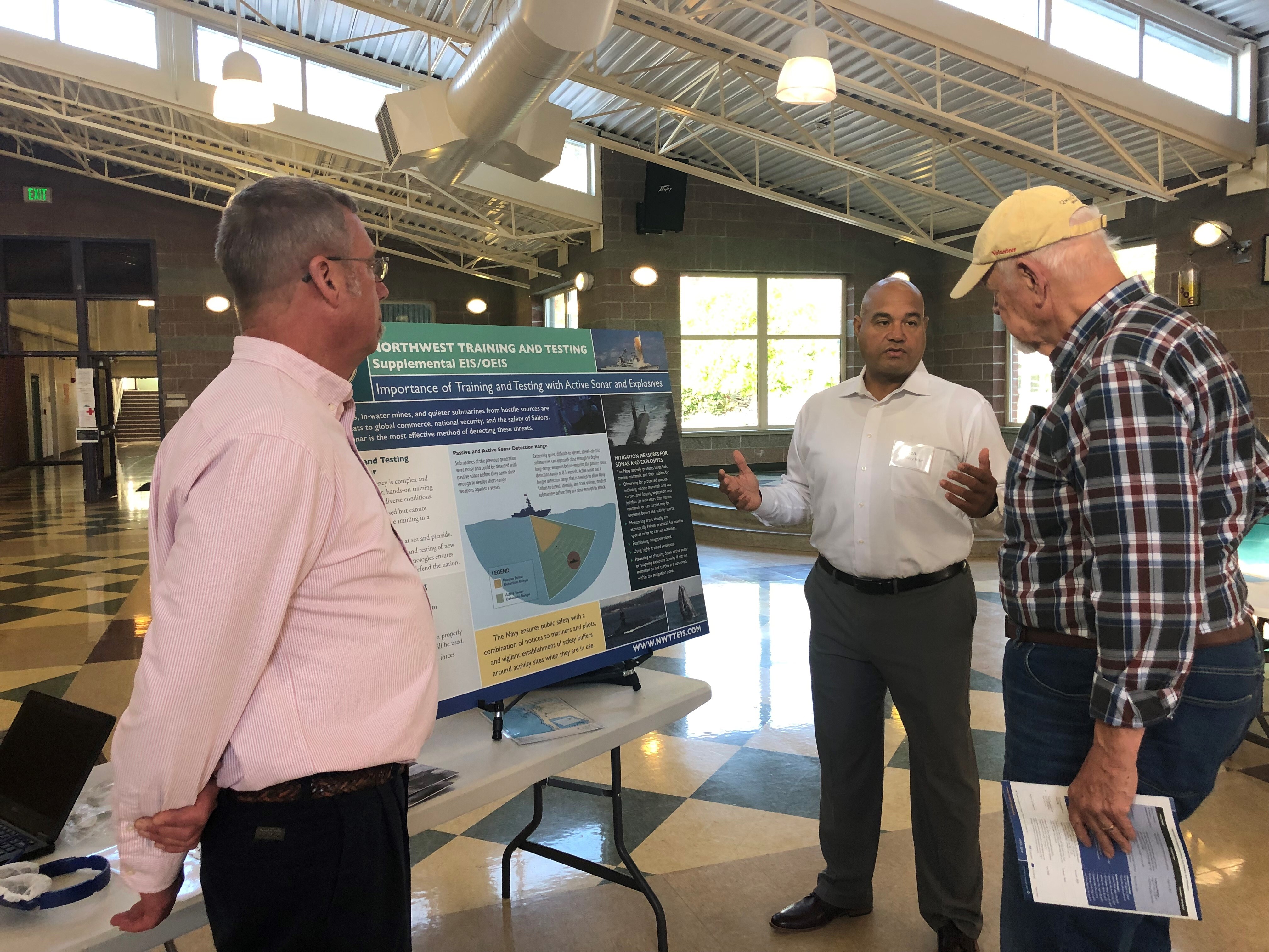 This is an image of a public meeting attendee speaking with Navy representatives at a public meeting held in the Pacific Northwest.